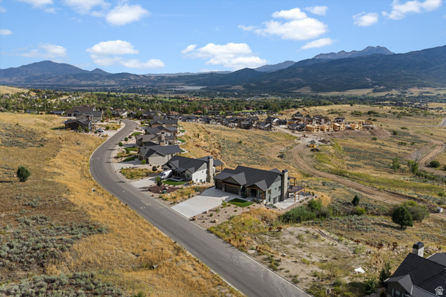 4499 North Seven Bridges Road, Unit 9 Eden, UT 84310 - Photo 56 of 65 Curved residential street with modern homes, mountain backdrop, and distant body of water