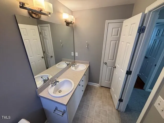 a bathroom with a sink mirror vanity and toilet