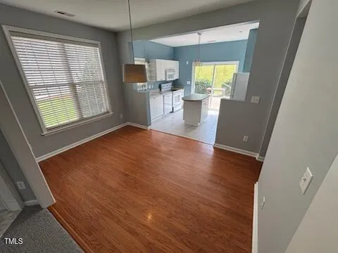 a view of a livingroom with a window and wooden floor