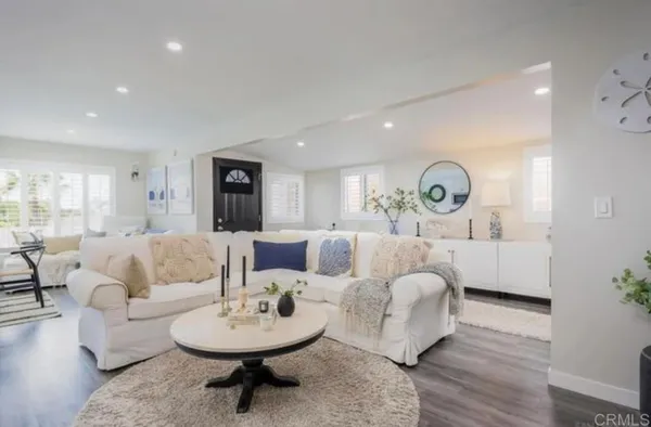 a living room with furniture a mirror and a table