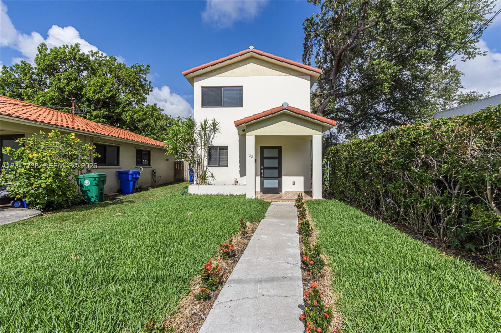 122 Southwest 56th Avenue Miami, FL 33144 - Photo 1 of 48 a front view of a house with a yard and trees