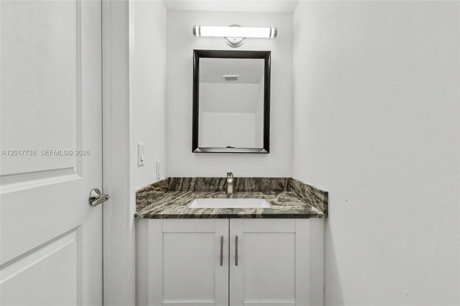 122 Southwest 56th Avenue Miami, FL 33144 - Photo 11 of 48 a bathroom with a granite countertop sink and a mirror