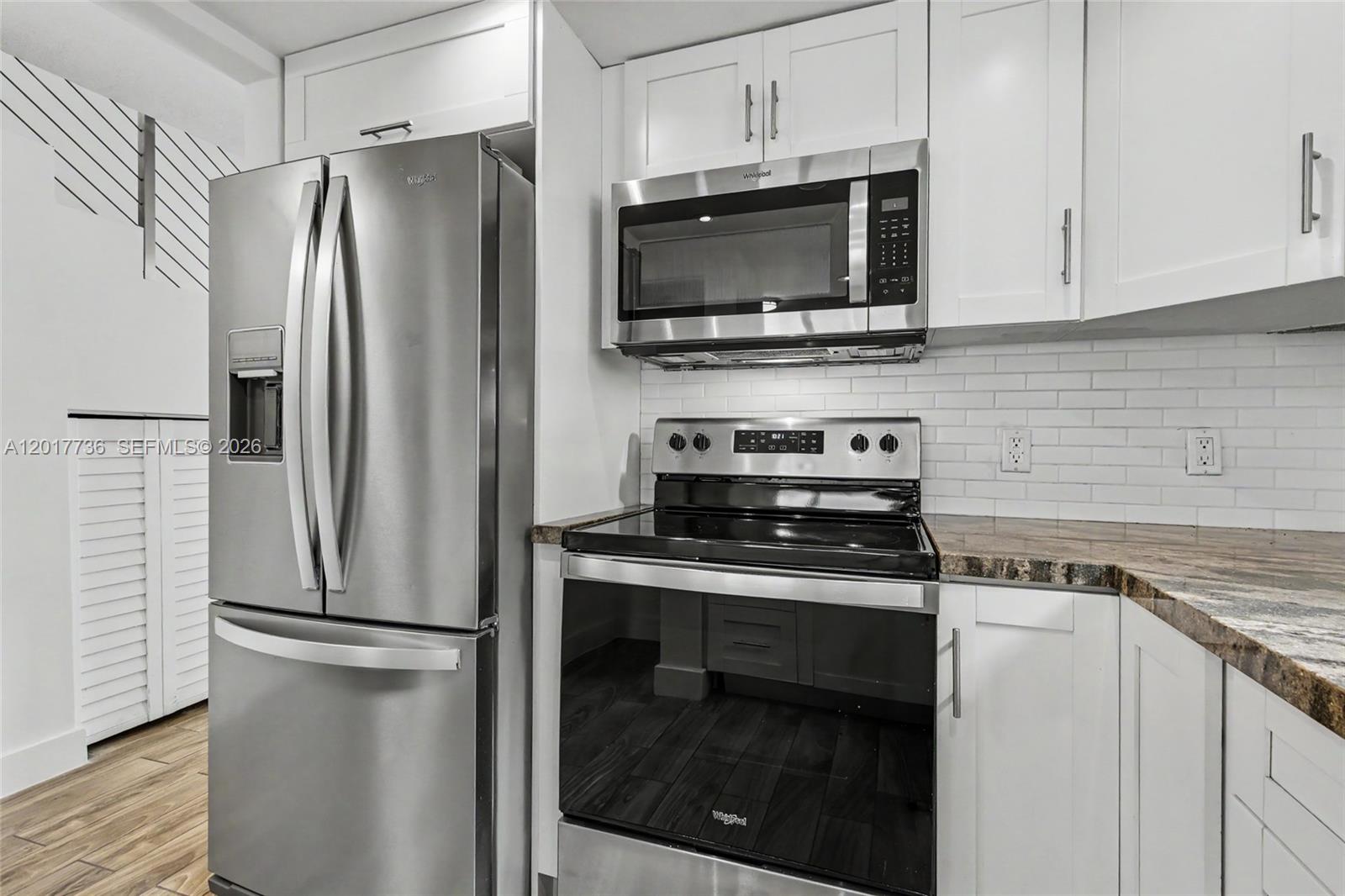 122 Southwest 56th Avenue Miami, FL 33144 - Photo 13 of 48 a kitchen with stainless steel appliances a refrigerator stove and microwave