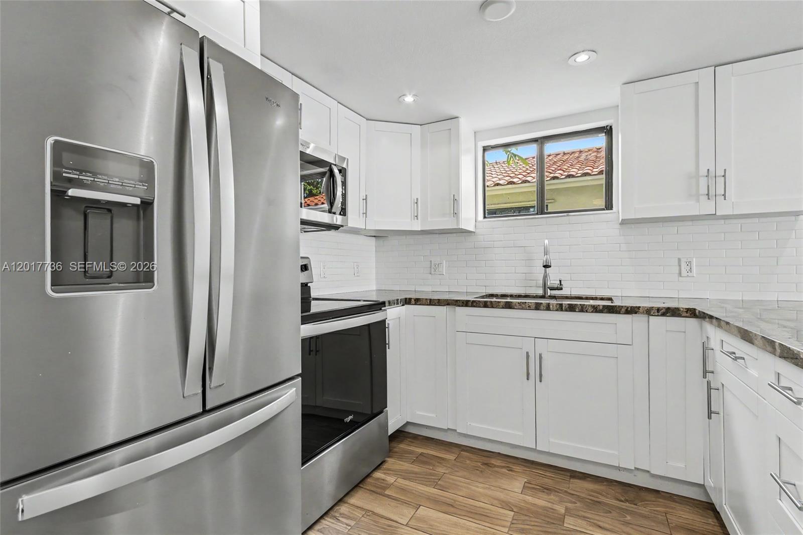 122 Southwest 56th Avenue Miami, FL 33144 - Photo 15 of 48 a kitchen with stainless steel appliances granite countertop a refrigerator and a stove top oven