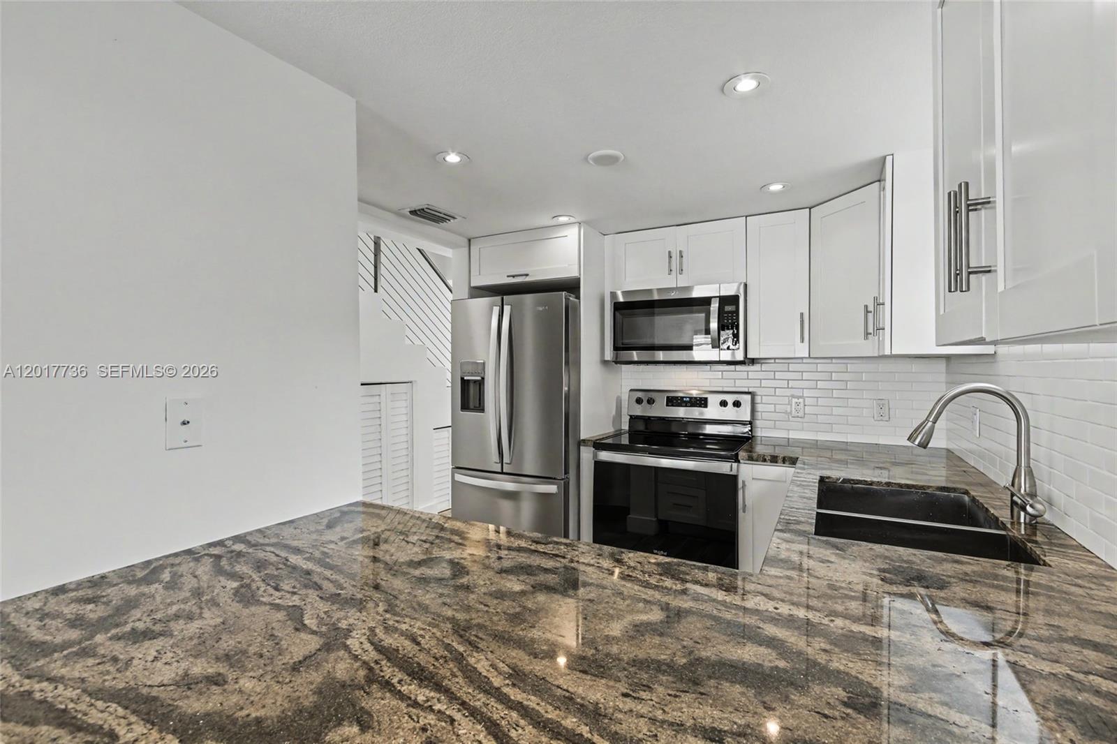 122 Southwest 56th Avenue Miami, FL 33144 - Photo 16 of 48 a kitchen with granite countertop a refrigerator stove and microwave