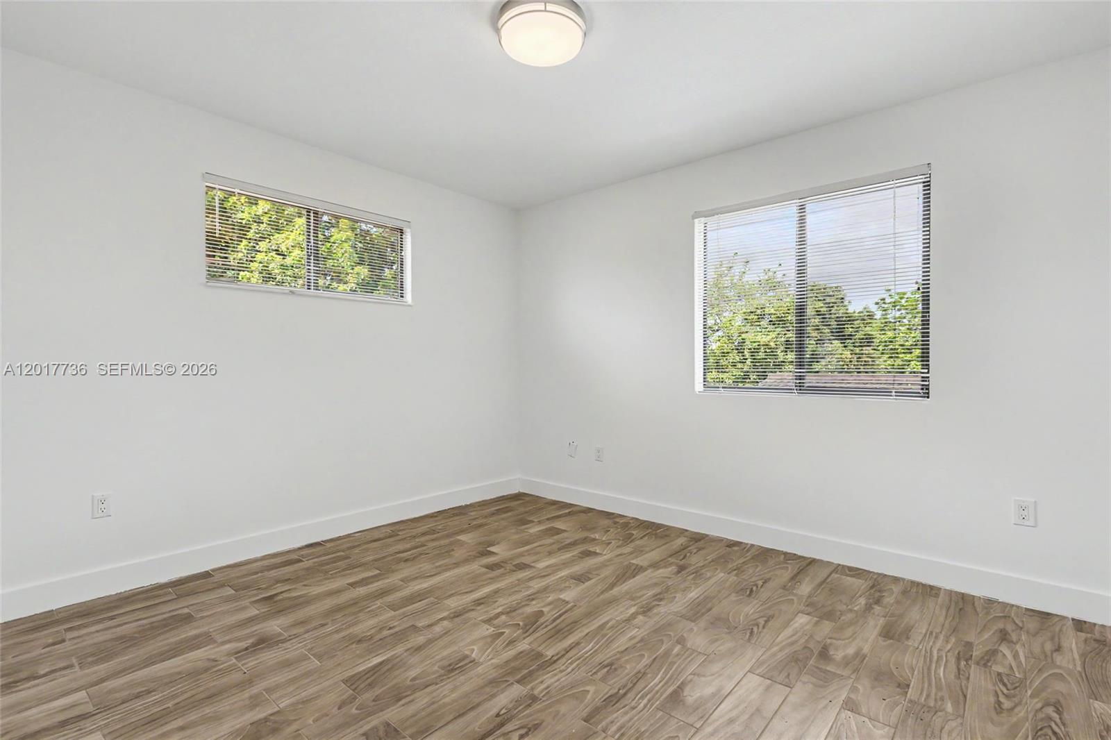 122 Southwest 56th Avenue Miami, FL 33144 - Photo 24 of 48 a view of an empty room with wooden floor and a window