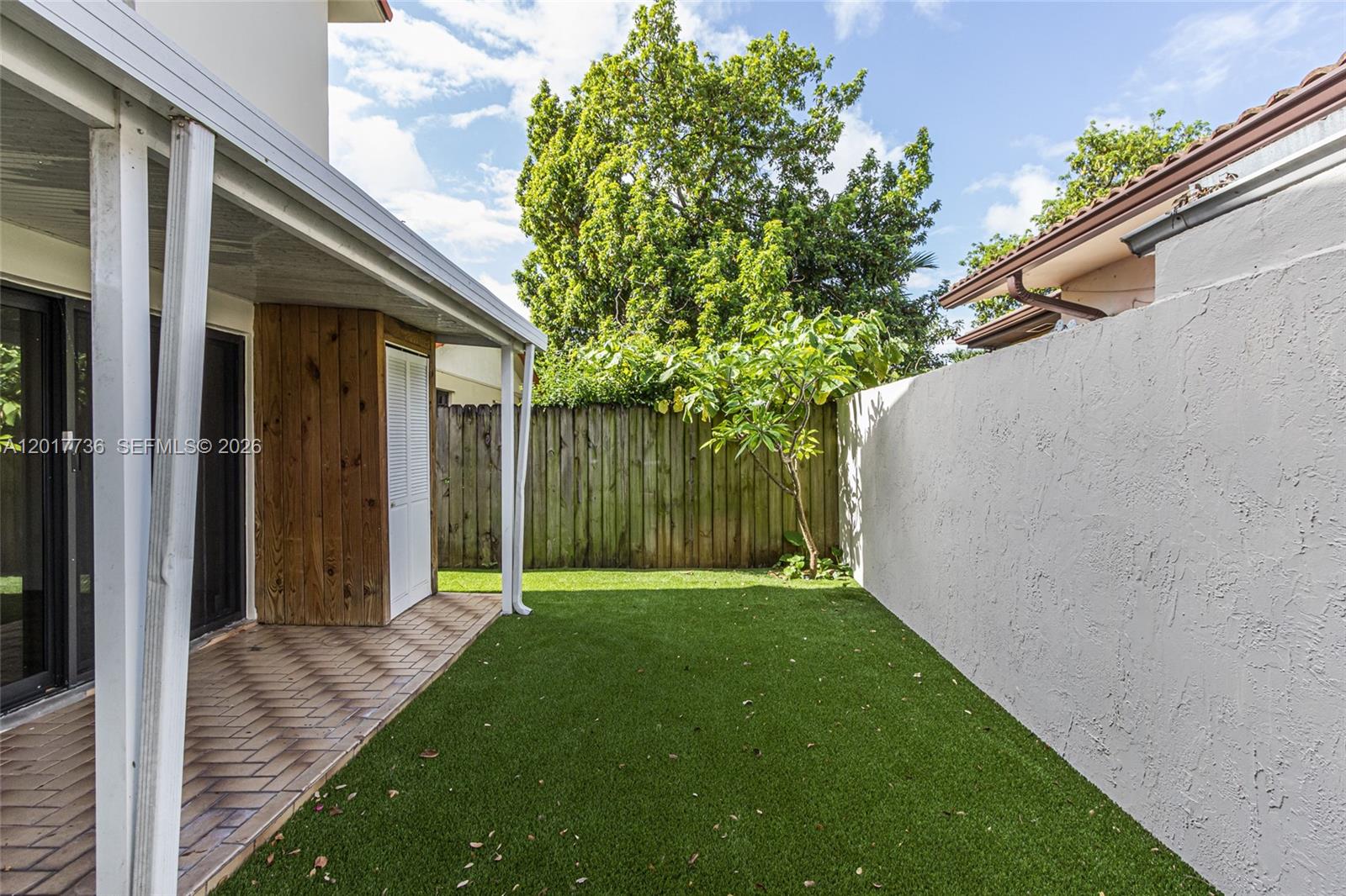122 Southwest 56th Avenue Miami, FL 33144 - Photo 38 of 48 a view of a backyard with potted plants and floor to ceiling window and wooden fence
