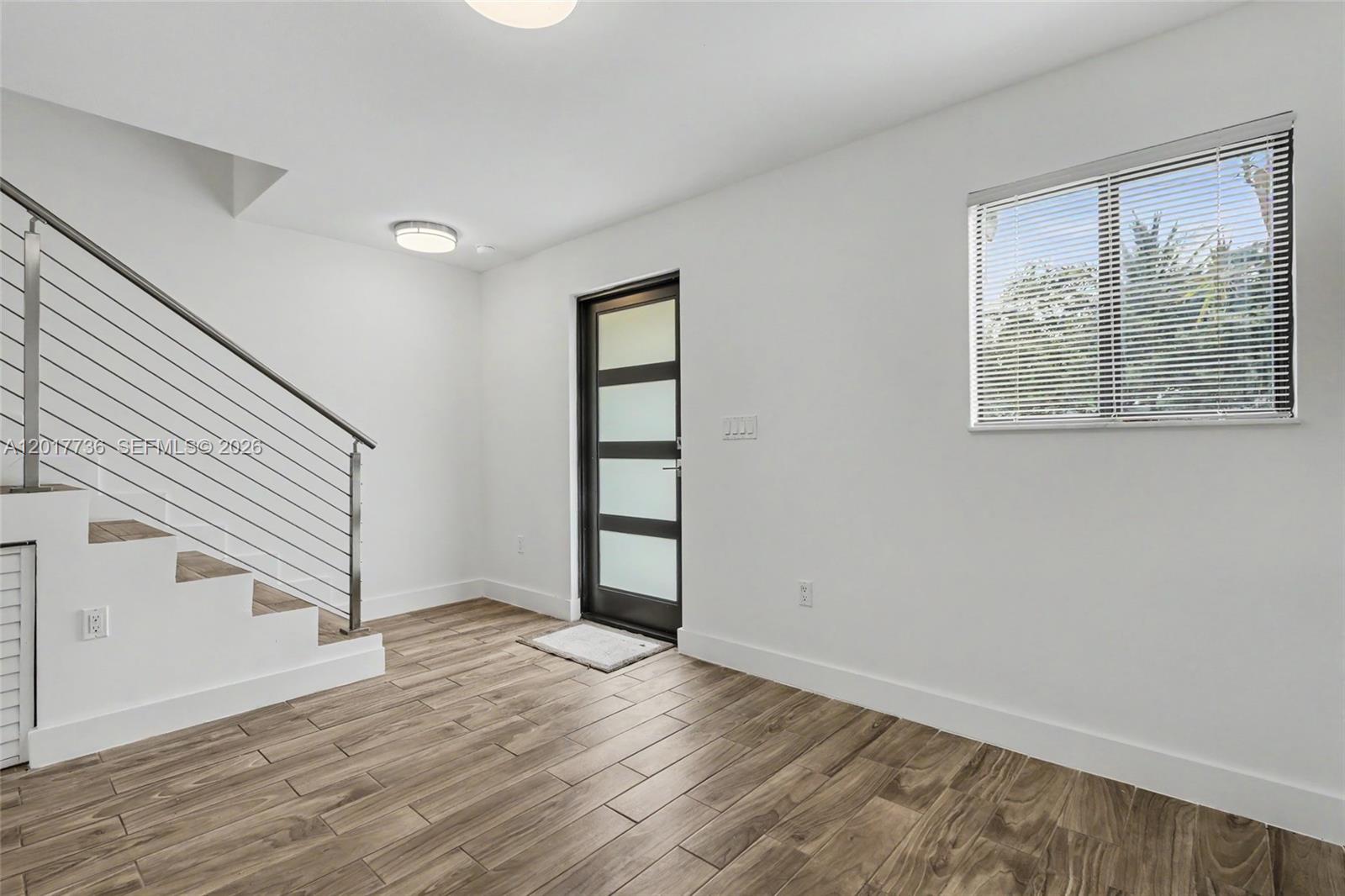 122 Southwest 56th Avenue Miami, FL 33144 - Photo 9 of 48 wooden floor in an empty room with a window