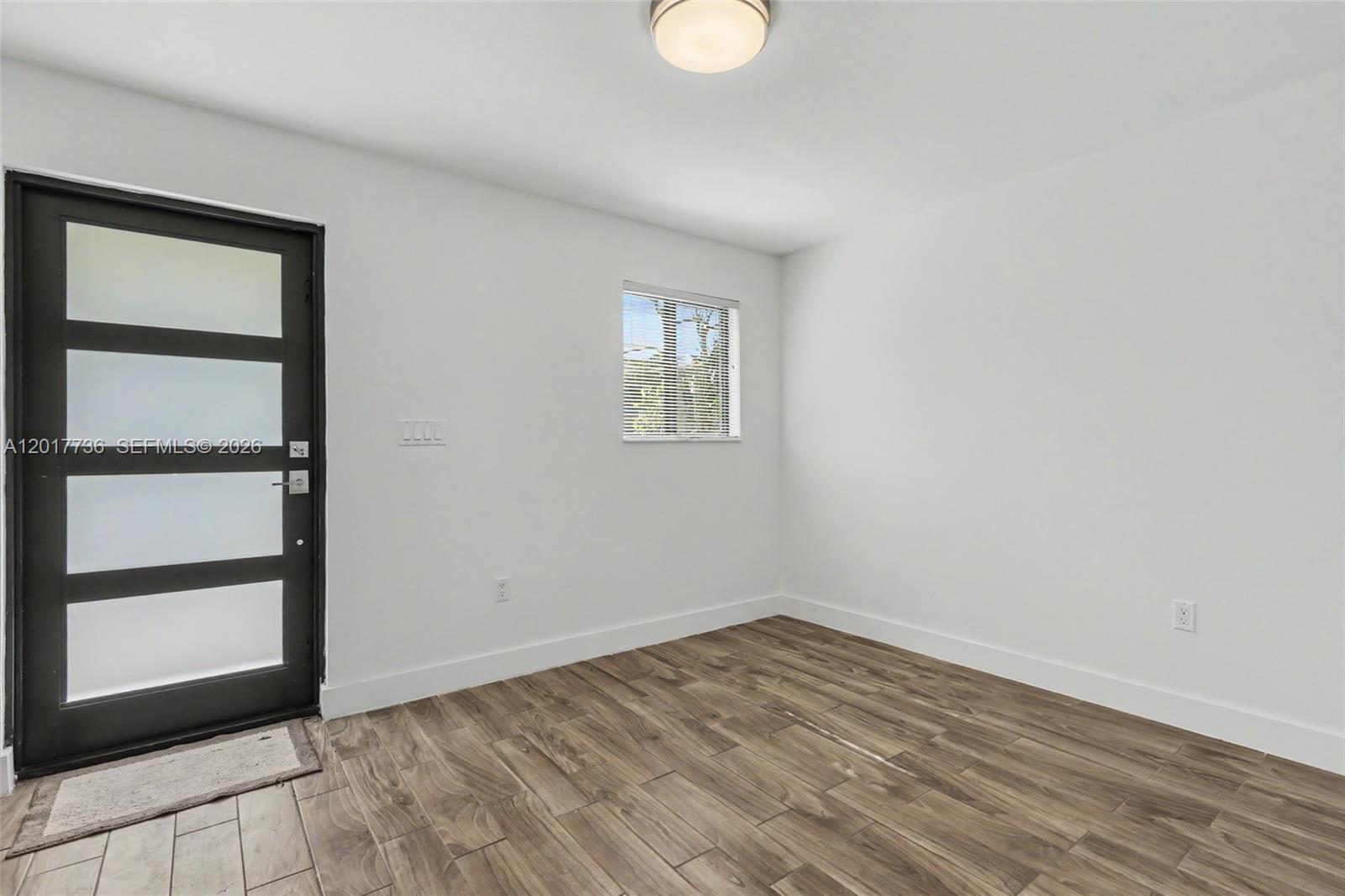 122 Southwest 56th Avenue Miami, FL 33144 - Photo 10 of 48 a view of empty room with wooden floor and fan