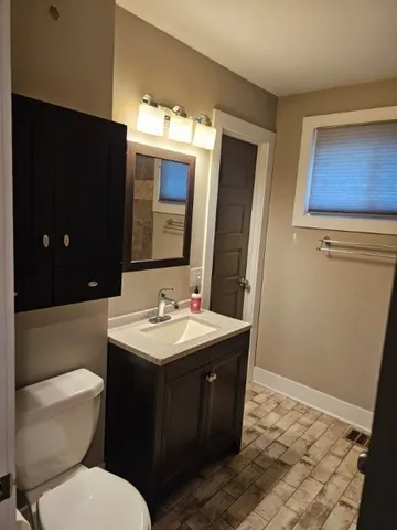 a bathroom with a toilet sink and mirror