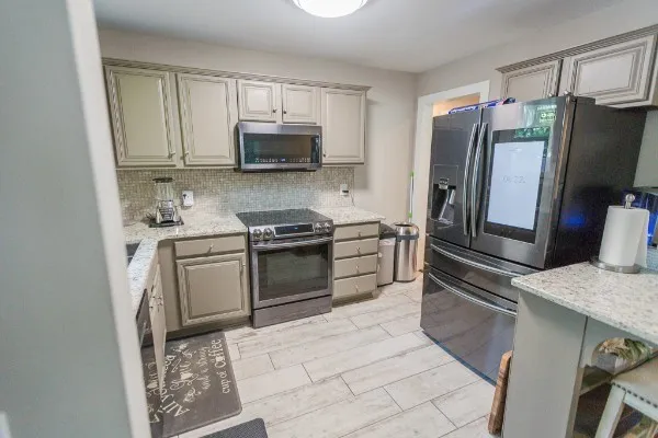 a kitchen with stainless steel appliances granite countertop a refrigerator stove and microwave