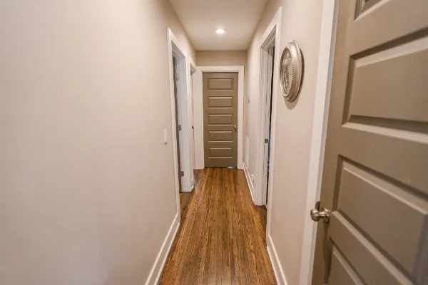 a view of a hallway with wooden floor and staircase