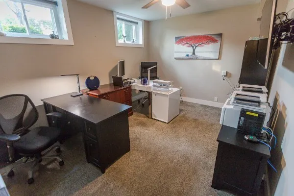 a view of a workspace with furniture and a window