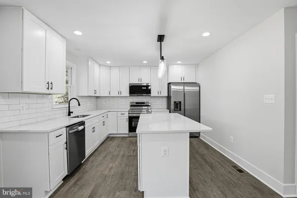 a kitchen with a sink a stove a refrigerator and cabinets