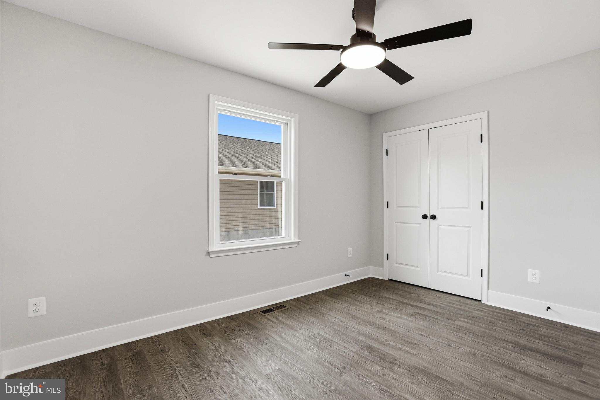 826 South Glebe Road Montross, VA 22520 - Photo 29 of 37 an empty room with wooden floor ceiling fan and windows