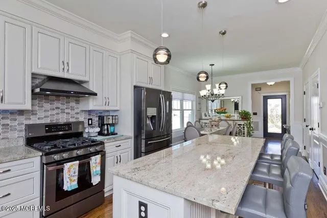 a kitchen with stainless steel appliances granite countertop a stove refrigerator sink and cabinets