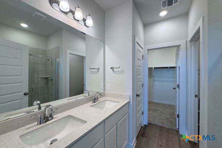 220 Escape Way Jarrell, TX 76537 - Photo 5 of 14 a bathroom with a double vanity sink and a mirror
