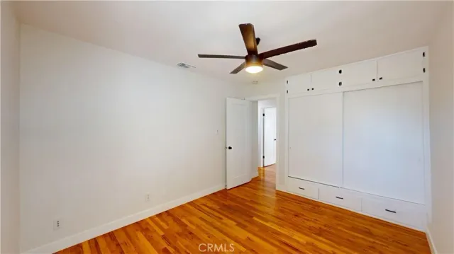 a view of empty room with wooden floor