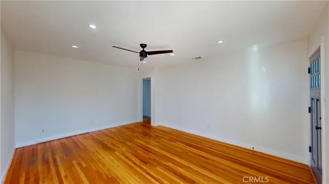a view of a big room with wooden floor and windows