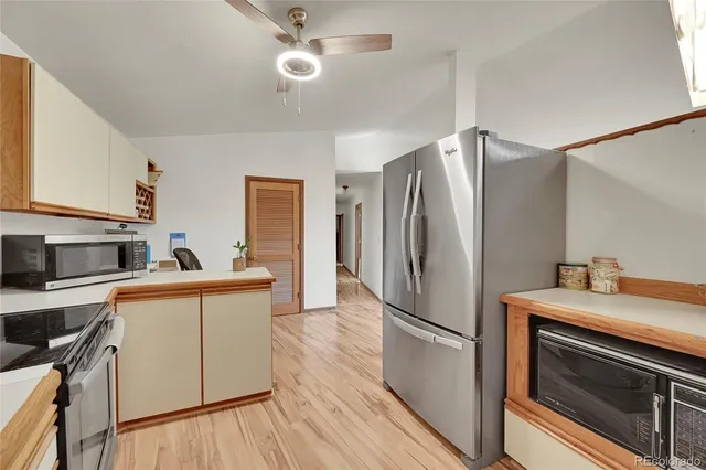 a kitchen with granite countertop a refrigerator stove and sink