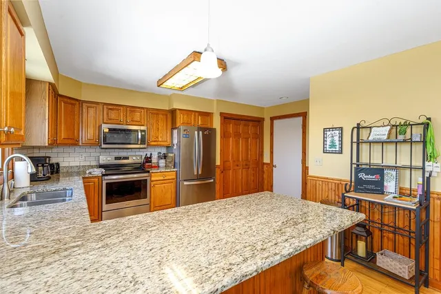 a large kitchen with stainless steel appliances granite countertop a sink and cabinets