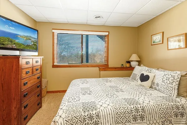 a bedroom with two beds and a dresser next to a window