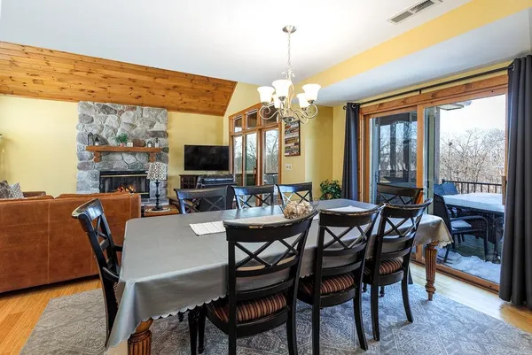 a view of a dining room with furniture a chandelier and large windows