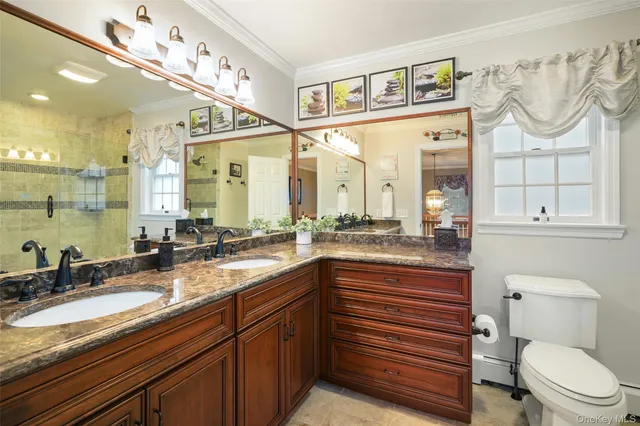 a bathroom with a granite countertop sink mirror vanity and toilet