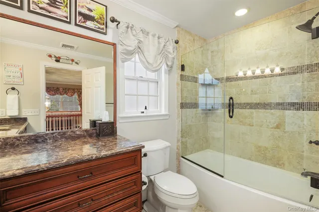 a bathroom with a granite countertop sink a toilet and shower