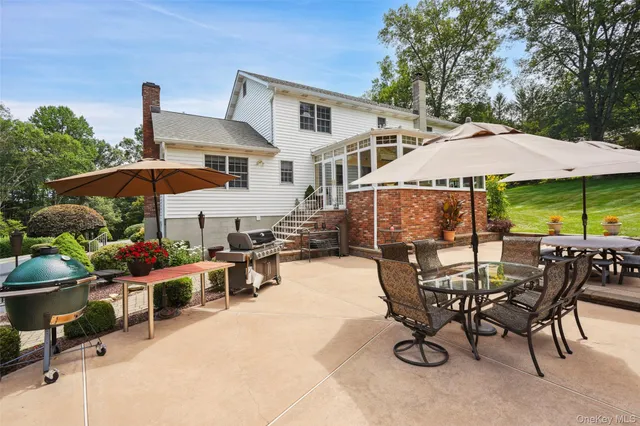 a patio with a table and chairs under an umbrella