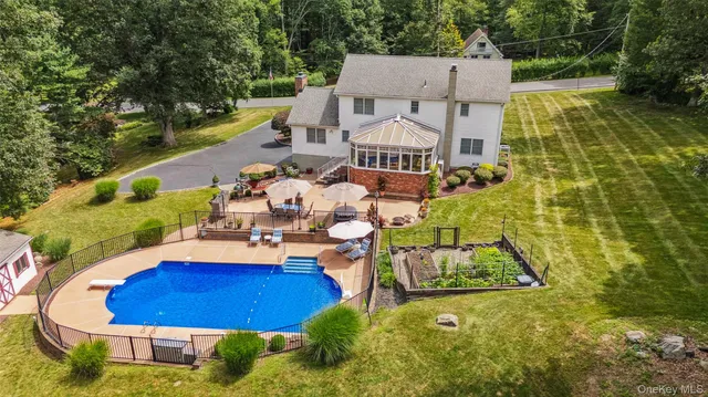 an aerial view of a house with swimming pool and outdoor seating
