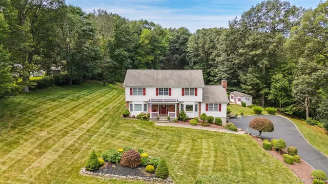 aerial view of a house with swimming pool lawn chairs and a yard