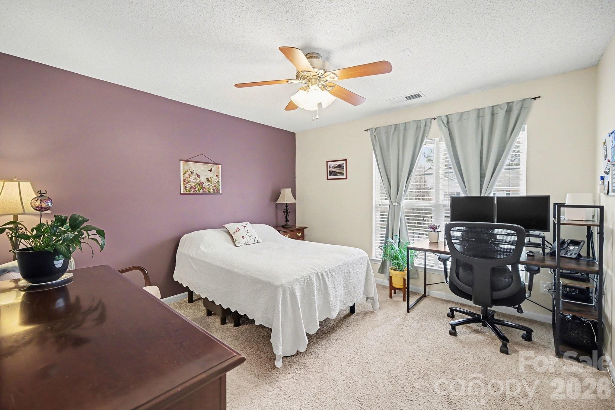 8048 Stoneham Court Matthews, NC 28105 - Photo 13 of 15 a bedroom with a bed and a chandelier