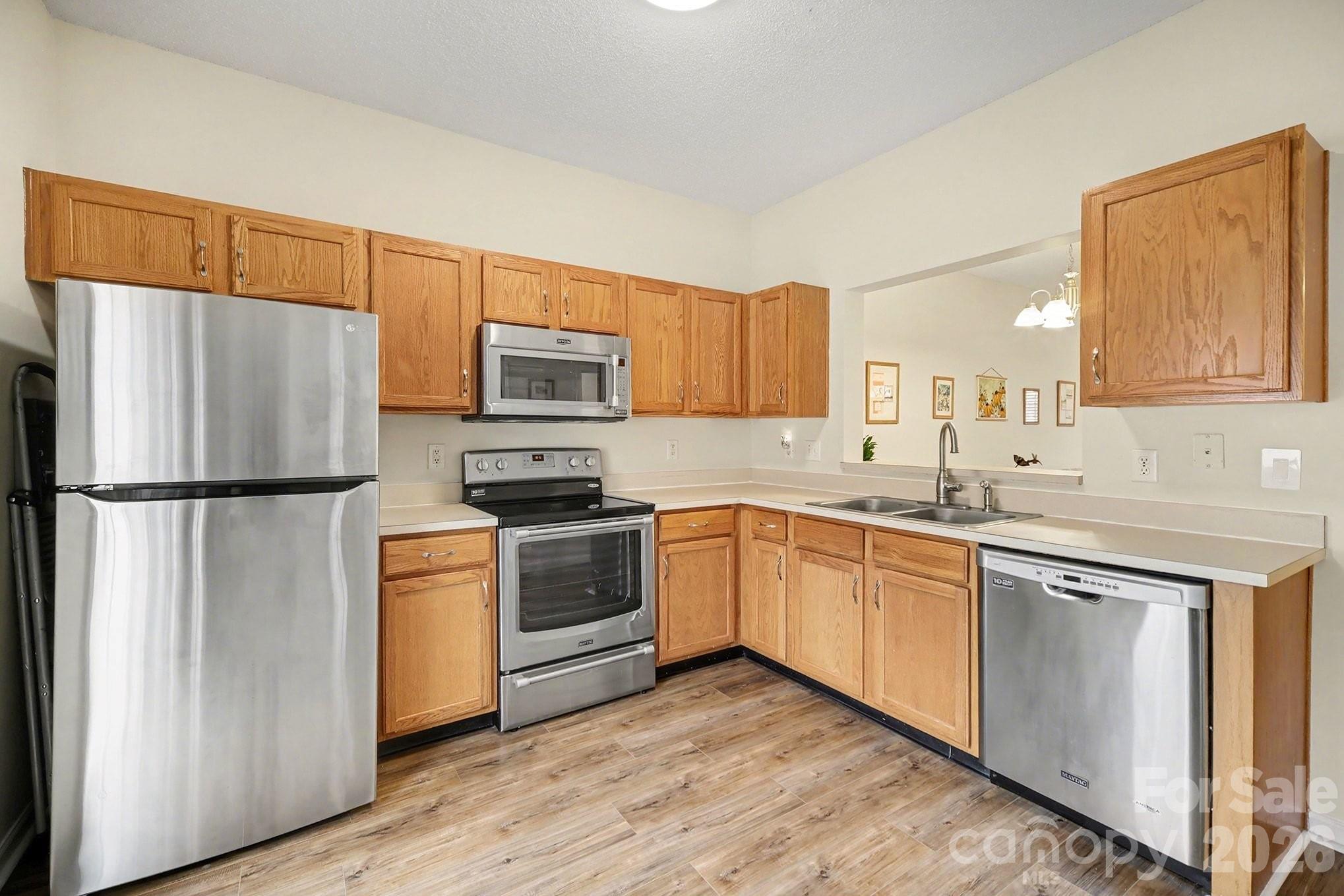 8048 Stoneham Court Matthews, NC 28105 - Photo 8 of 15 a kitchen with granite countertop a refrigerator stove top oven and sink