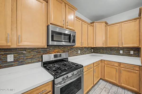 a kitchen with granite countertop a sink stove and microwave