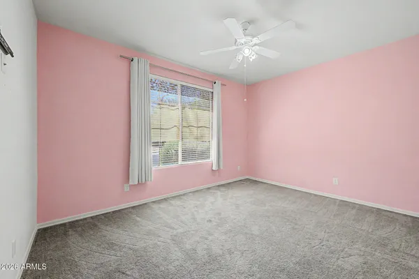 an empty room with windows and fan