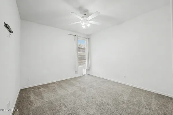 an empty room with closet and ceiling fan