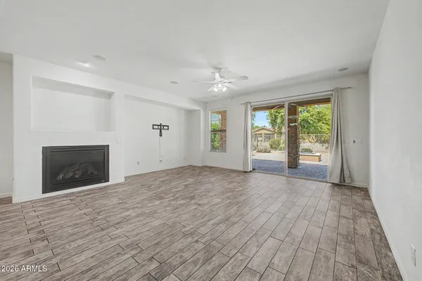 wooden floor fireplace and windows in an empty room