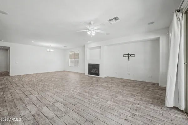 a view of empty room with wooden floor