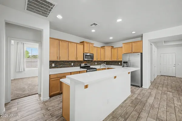 a kitchen with stainless steel appliances kitchen island sink refrigerator and cabinets