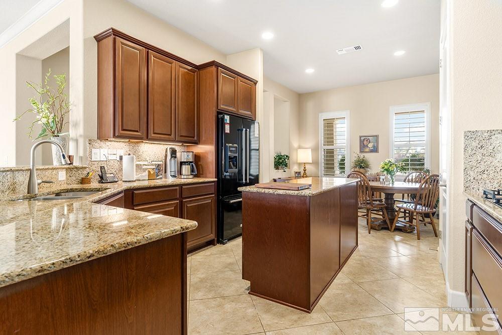 9266 Maplehurst Trail Reno, NV 89523 - Photo 26 of 29 a kitchen with kitchen island granite countertop a sink stove and cabinets