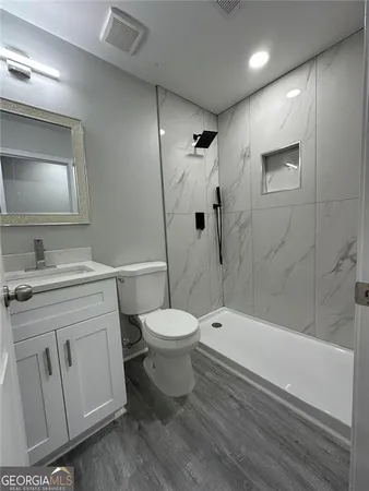 a bathroom with a toilet sink vanity tub and shower