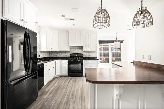 a kitchen with granite countertop stainless steel appliances a counter space and a window