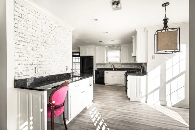 a kitchen with stainless steel appliances kitchen island granite countertop a stove a sink and a refrigerator