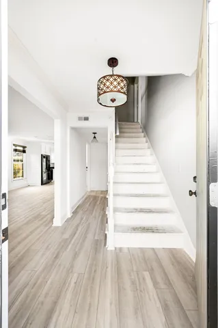 a view of a hallway with wooden floor and staircase