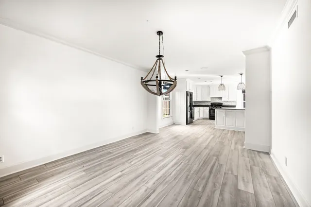 a view of empty room with wooden floor