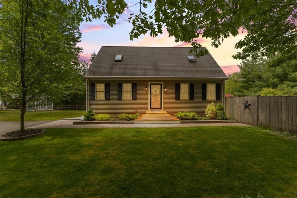 a front view of a house with yard and green space