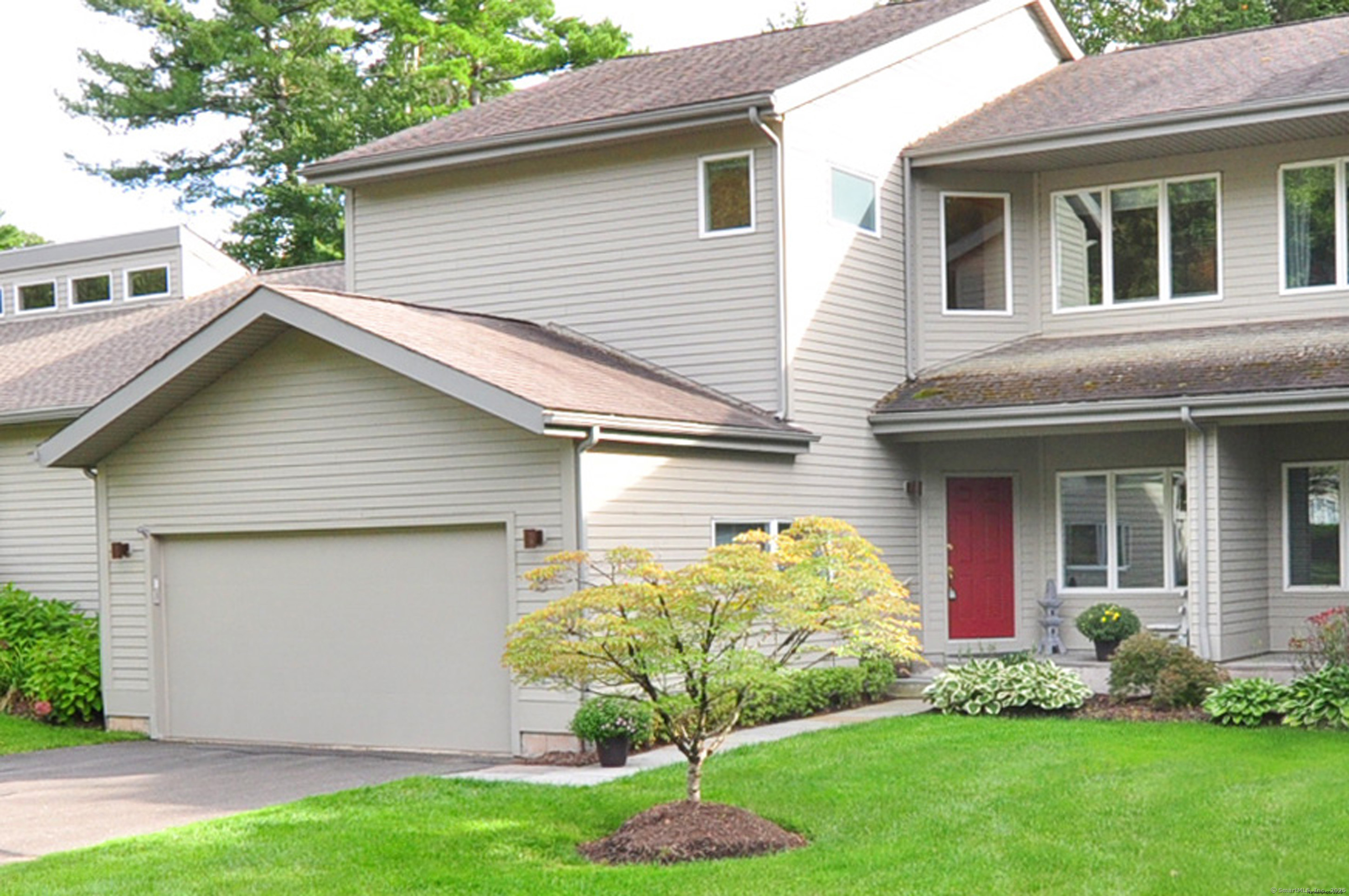 a front view of a house with a garden and plants