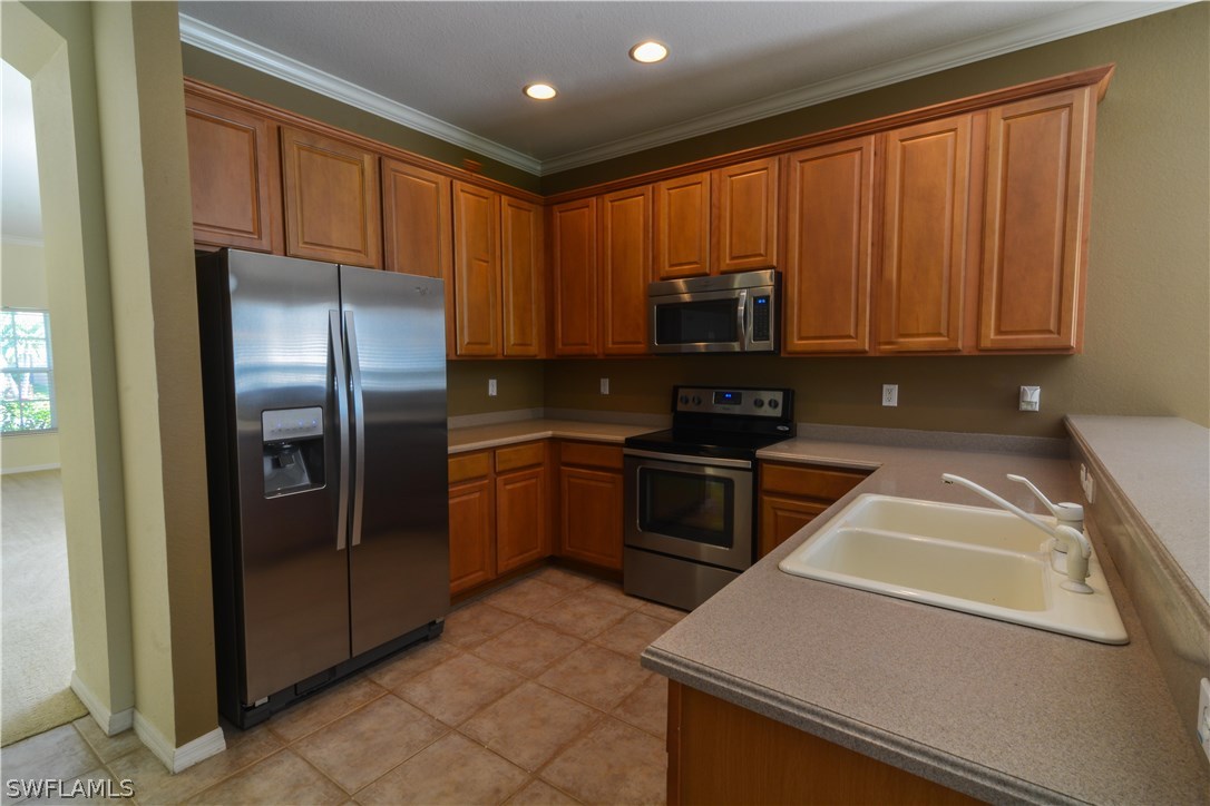 8960 Falcon Pointe Loop Fort Myers, FL 33912 - Photo 7 of 25 a kitchen with granite countertop a refrigerator and a stove top oven