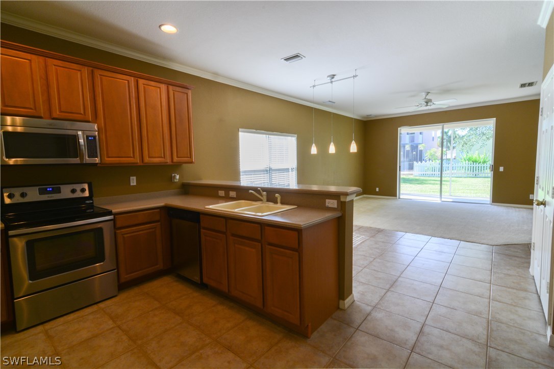8960 Falcon Pointe Loop Fort Myers, FL 33912 - Photo 9 of 25 a kitchen with stainless steel appliances granite countertop a stove a sink and a microwave